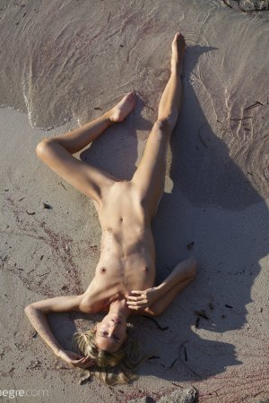 Голожопая тощая девка в песке на пляже